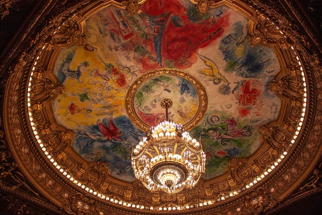 Ornate chandelier hangs from a painted ceiling — Photo by Kamilla Isalieva on Unsplash