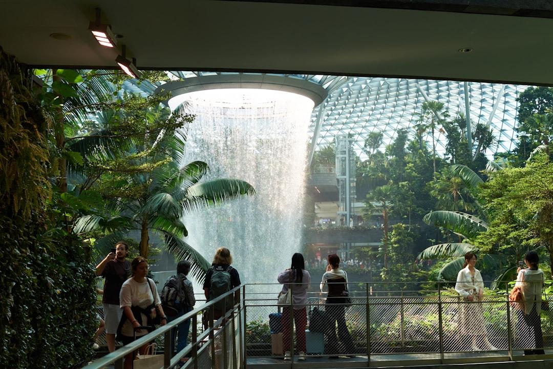 People admire a large indoor waterfall surrounded by greenery. — Photo by Harry Le on Unsplash