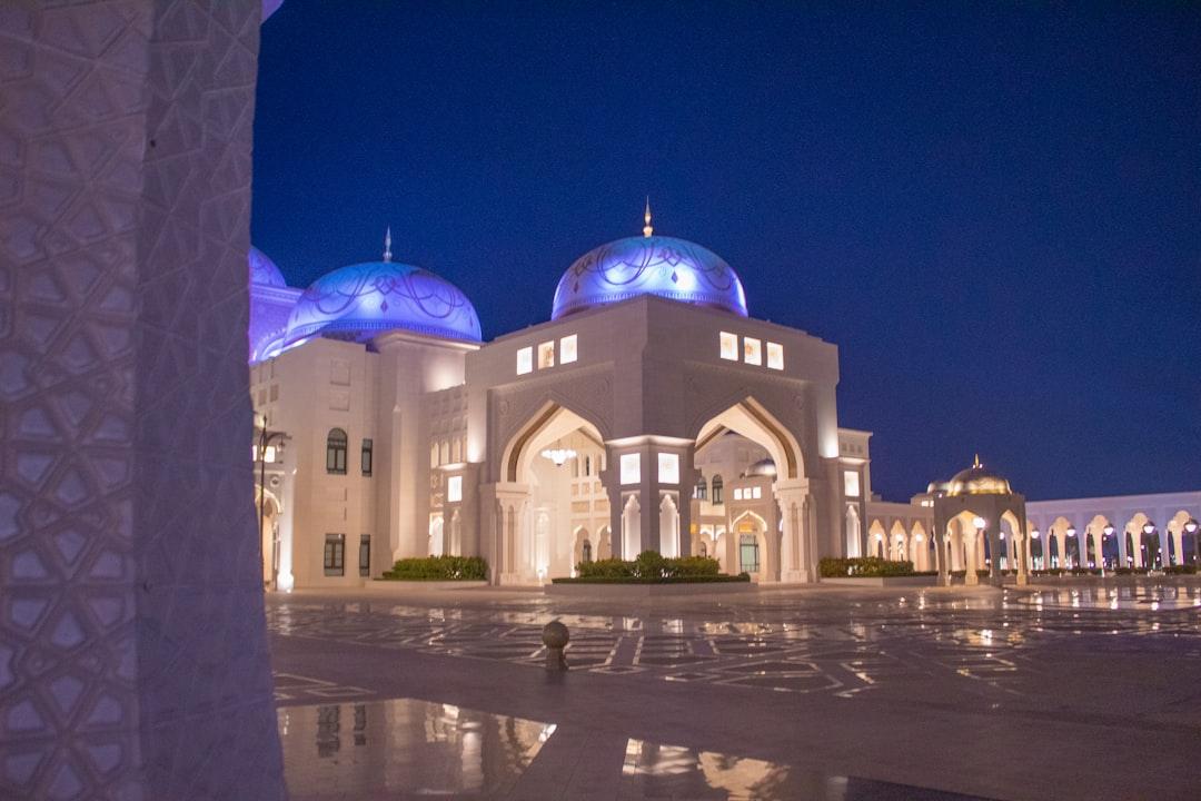 a large white building with blue domes at night — Photo by Rodrigo Castro on Unsplash