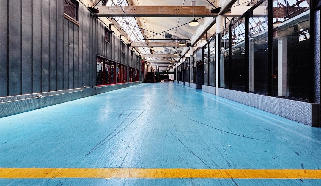 A large room with a blue floor and a yellow line — Photo by Tommy Bond on Unsplash