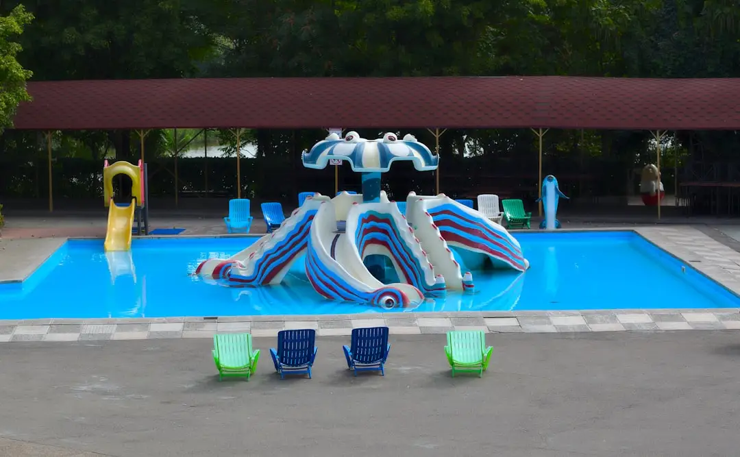 Pool with slides and lounge chairs is shown. — Photo by Aleksandr Sobolev on Unsplash