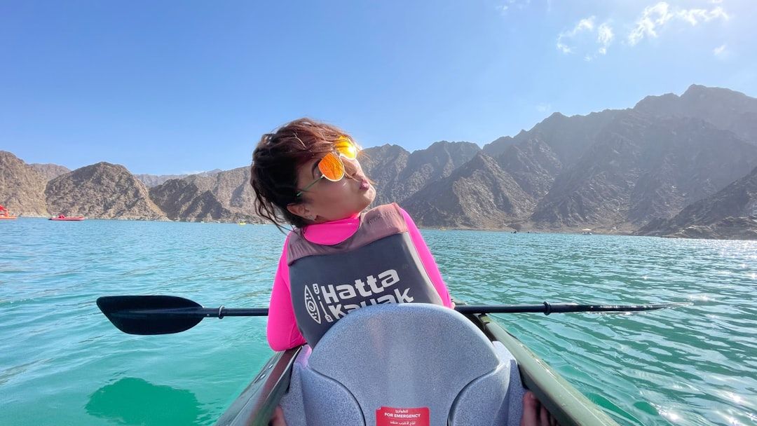 woman in pink and yellow life vest sitting on boat during daytime — Photo by Abdelkader Kherbouche on Unsplash