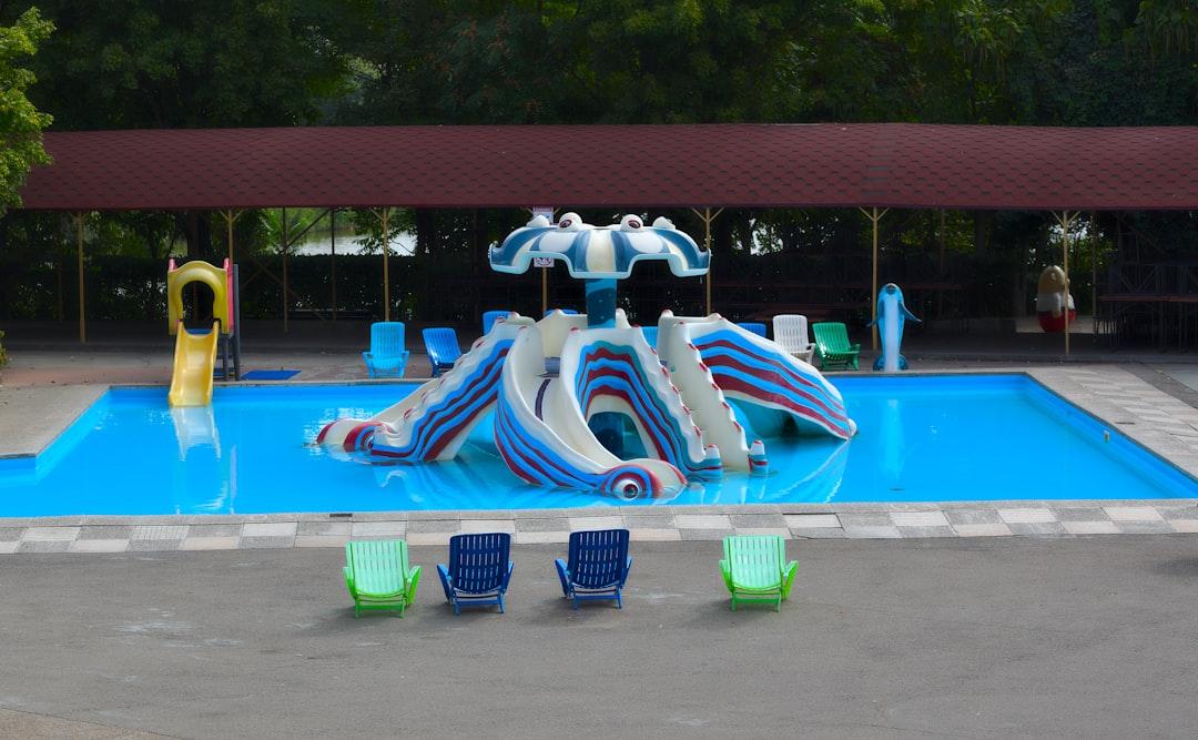 Pool with slides and lounge chairs is shown. — Photo by Aleksandr Sobolev on Unsplash