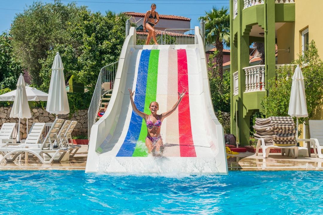 a woman on a water slide in a pool — Photo by Vitolda Klein on Unsplash