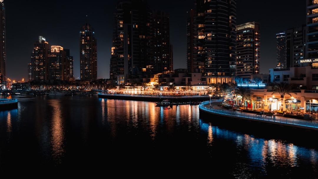 a city skyline at night with a river running through it — Photo by Mubaris Nendukanni on Unsplash