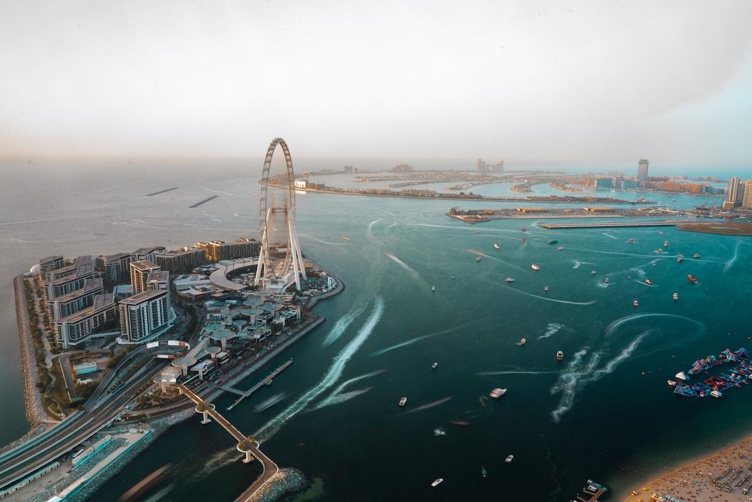 A ferris wheel towers over the water and the city. — Photo by Nejc Soklič on Unsplash
