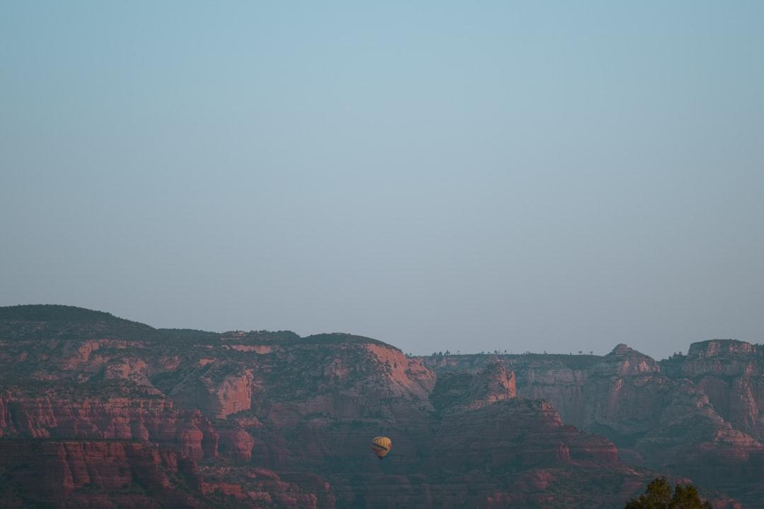 a hot air balloon flying over a mountain range — Photo by Jacob Diehl on Unsplash