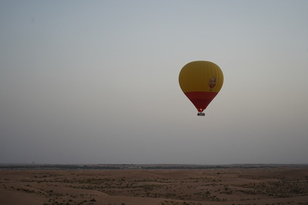 a yellow and red hot air balloon flying in the sky — Photo by Maximus Beaumont on Unsplash