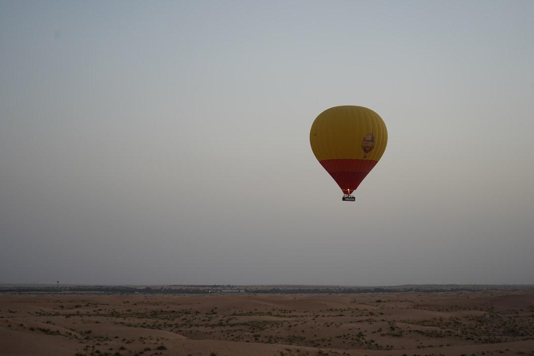 a yellow and red hot air balloon flying in the sky — Photo by Maximus Beaumont on Unsplash