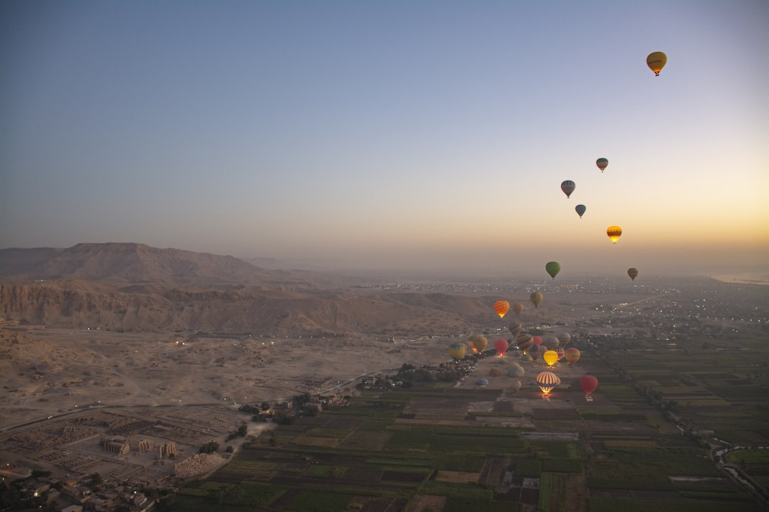Hot air balloons float over a river valley at sunrise. — Photo by claude elmoznino on Unsplash
