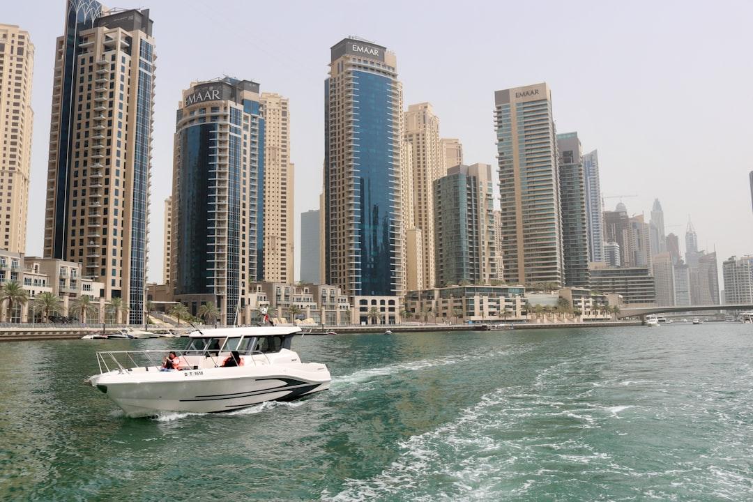 white boat on sea near high rise buildings during daytime — Photo by Likith T on Unsplash
