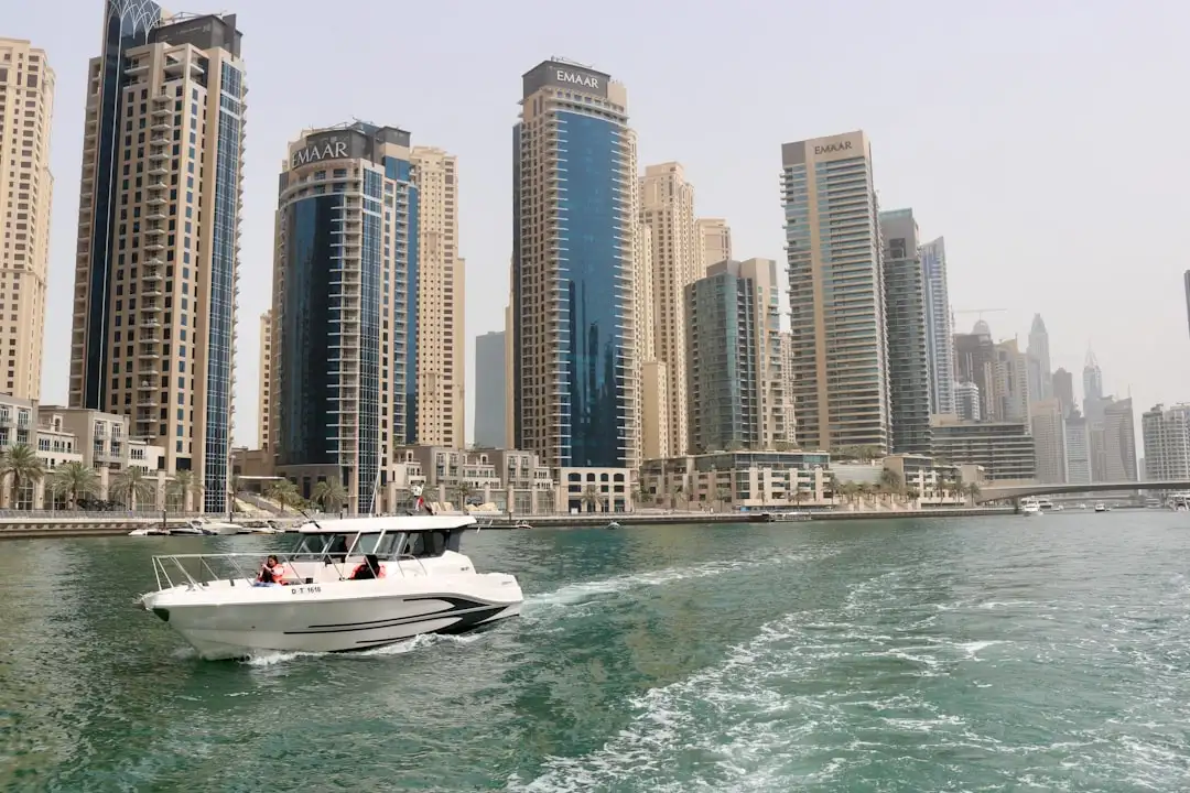white boat on sea near high rise buildings during daytime — Photo by Likith T on Unsplash