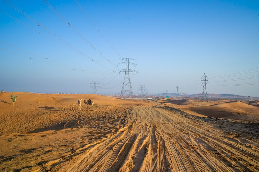 a dirt road in the middle of a desert — Photo by Julius Yls on Unsplash