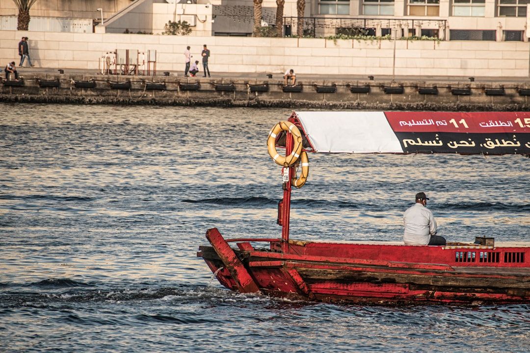 a man sitting in a red boat in the water — Photo by aboodi vesakaran on Unsplash