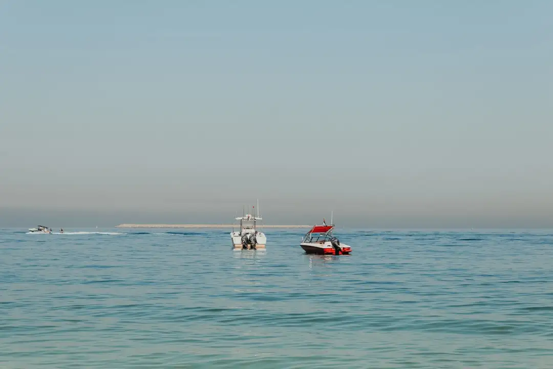 A couple of boats floating on top of a large body of water — Photo by Kate Trysh on Unsplash