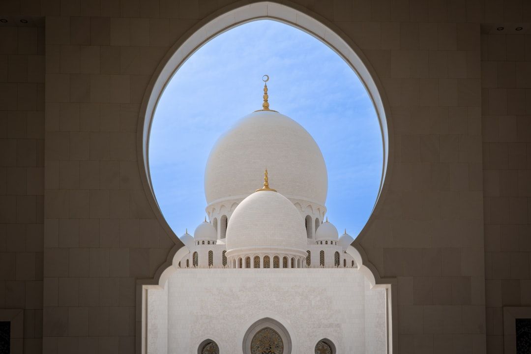A mosque dome is seen through an archway. — Photo by Nick Fewings on Unsplash
