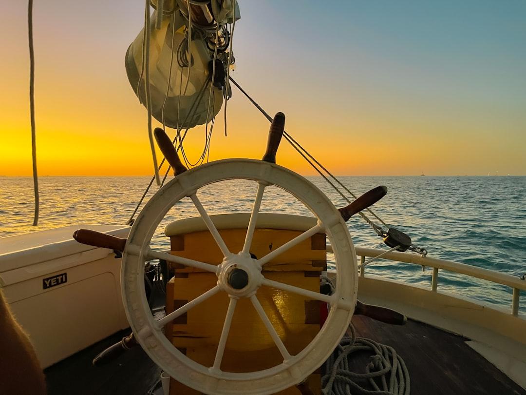 the wheel of a boat in the ocean at sunset — Photo by Arian R on Unsplash