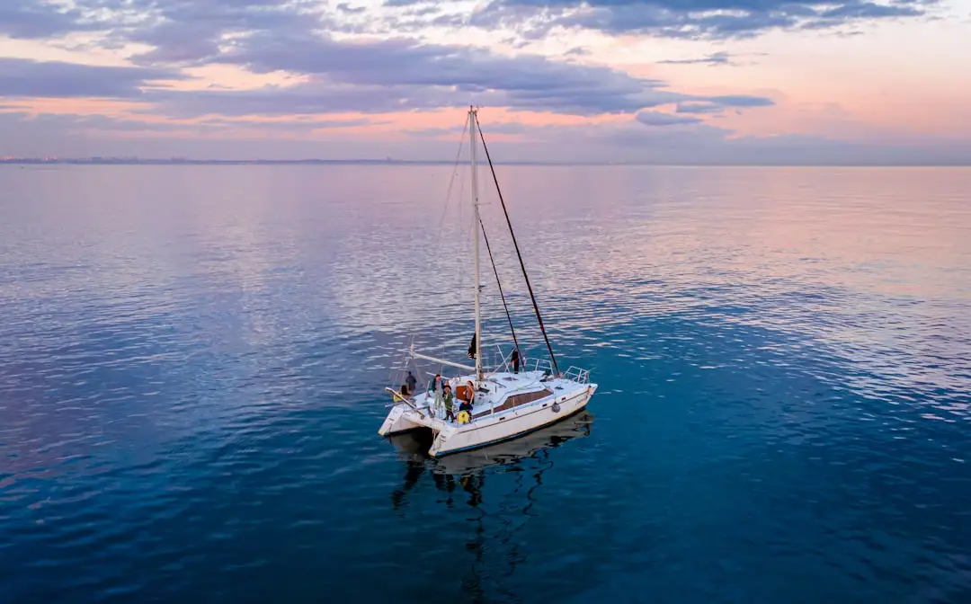 a sailboat floating in the middle of a large body of water — Photo by Alexander on Unsplash