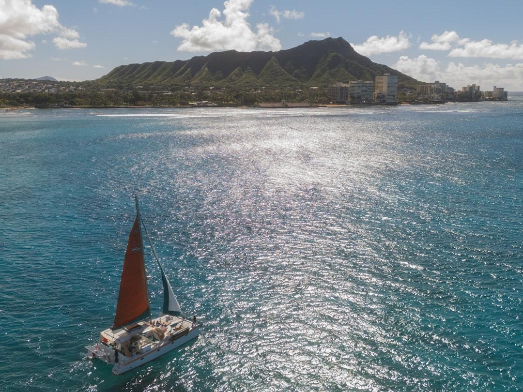 A sailboat sails near diamond head, hawaii. — Photo by User_Pascal on Unsplash