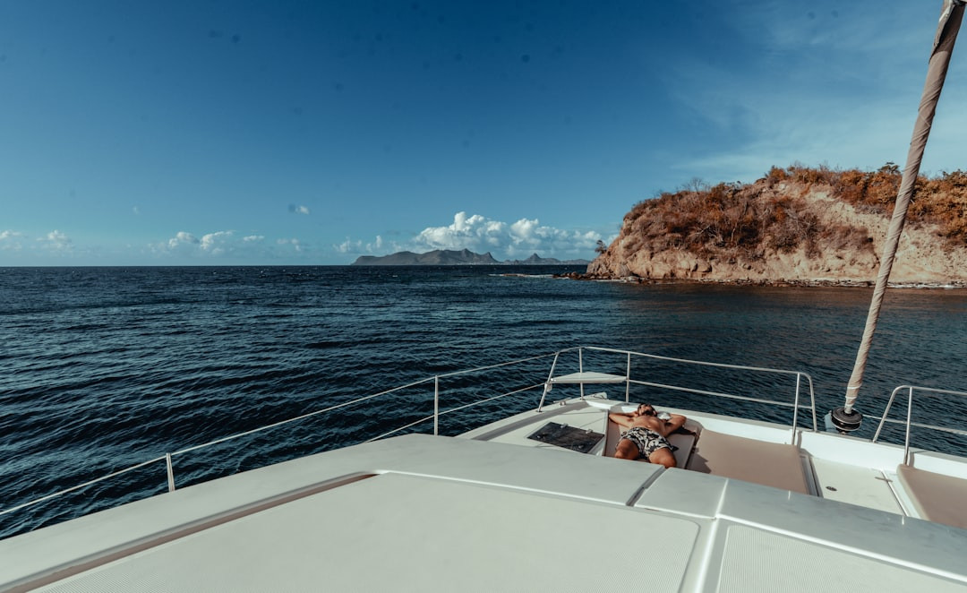 Sailing on a calm blue ocean towards a rocky island — Photo by Hugh Whyte on Unsplash