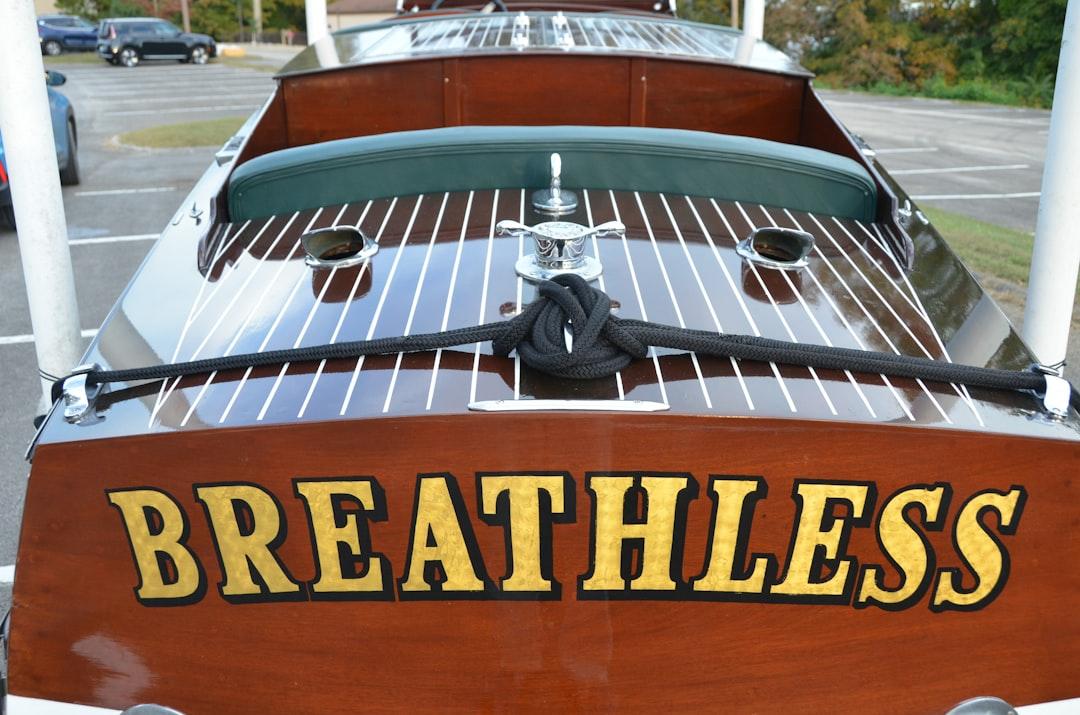 Wooden boat named breathless on a dock — Photo by Roger Starnes Sr on Unsplash