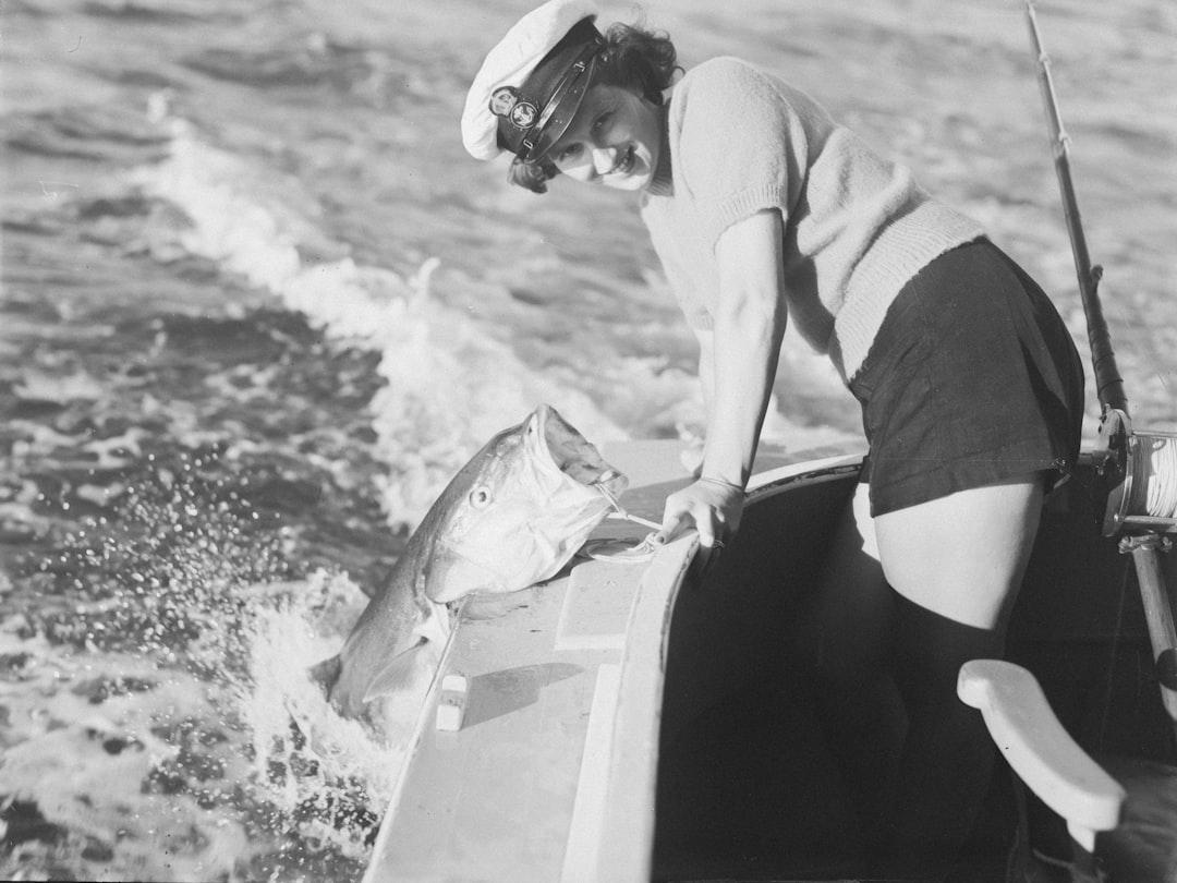 Woman proudly displays a large fish caught while fishing. — Photo by Auckland War Memorial Museum Tāmaki Paenga Hira on Unsplash