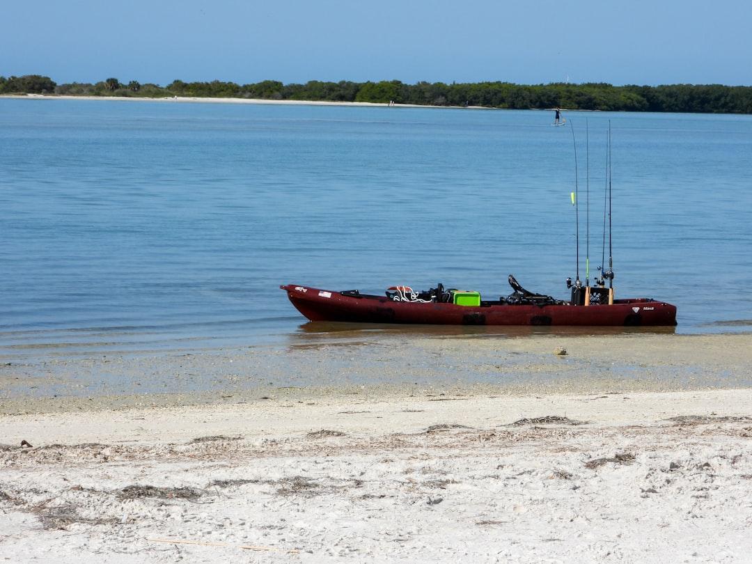 A kayak with fishing rods on calm water — Photo by Anita Denunzio on Unsplash