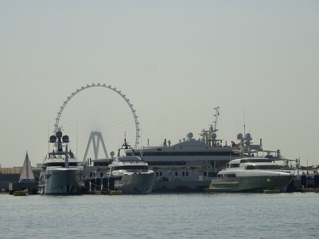 A ferris wheel and several boats in the water — Photo by Robin E on Unsplash